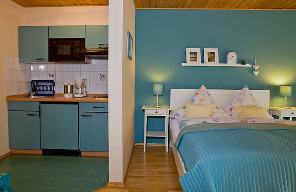 Küchenzeile und Schlafraum - Ferienwohnung Lusen